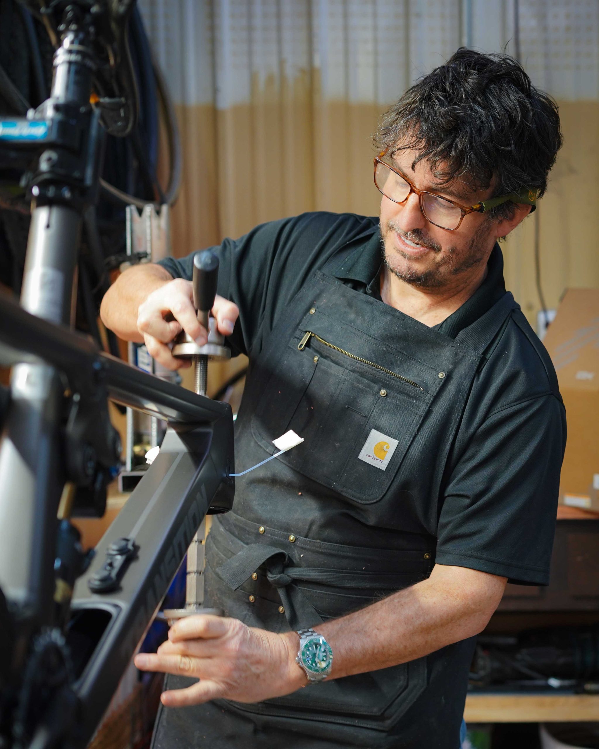 Ryan Kelley working on a bike at a repair stand in the shop.
